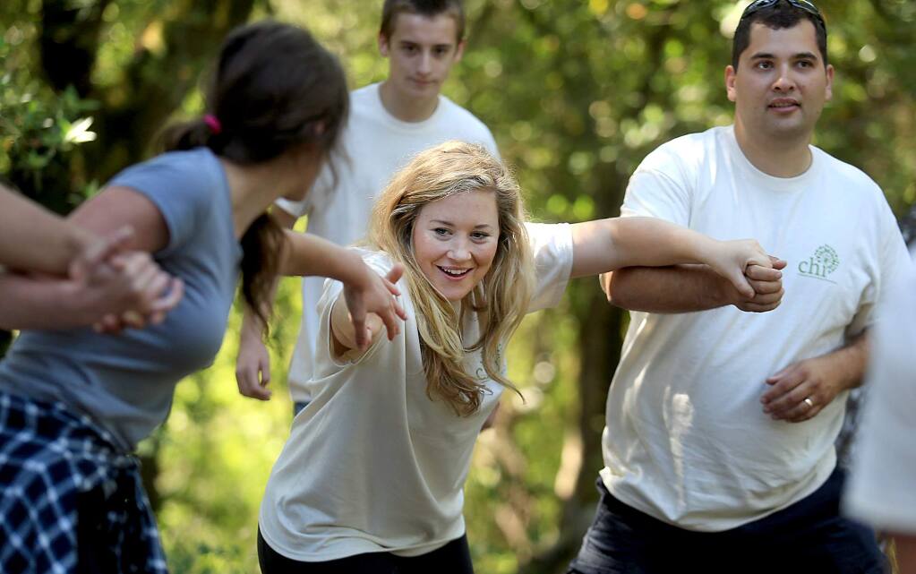 Lauren Taylor, middle, chaperone for Children's Humanitarian International, a nonprofit organization founded by SRJC board member Jordan Burns, right, takes part in a team building exercise at the Four Winds top course in Occidental, Thursday June 30, 2016. (Kent Porter / Press Democrat) 2016
