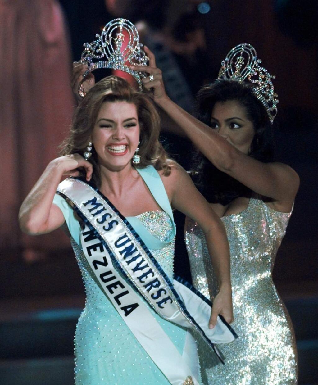 FILE - In this May 17, 1996, file photo, the new Miss Universe Alicia Machado of Venezuela reacts as she is crowned by the 1995 winner Chelsi Smith at the Miss Universe competition in Las Vegas. Machado became a topic of conversation during the first presidential debate between Republican nominee Donald Trump and Democratic candidate Hillary Clinton on Sept. 27, 2016. (AP Photo/Eric Draper, File)