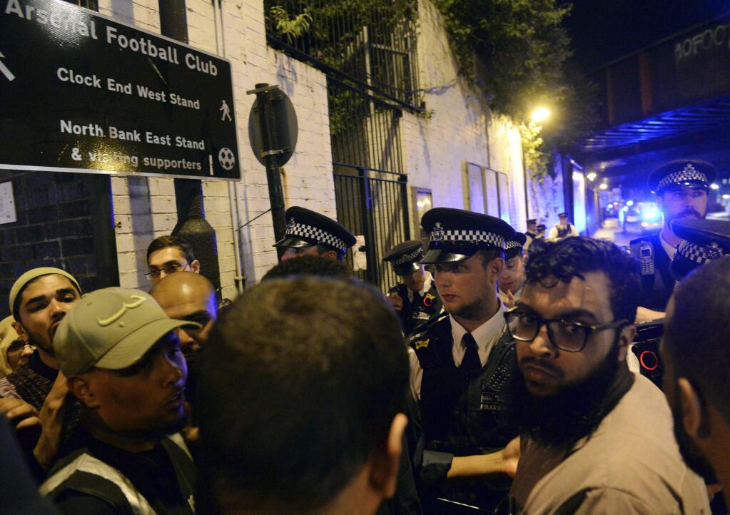 Police officers talk with local people at the Finsbury Park in north London, where a vehicle struck pedestrians Monday, June 19, 2017. A vehicle struck pedestrians near a mosque in north London early Monday morning, causing several casualties, police said. (Yui Mok/PA via AP)