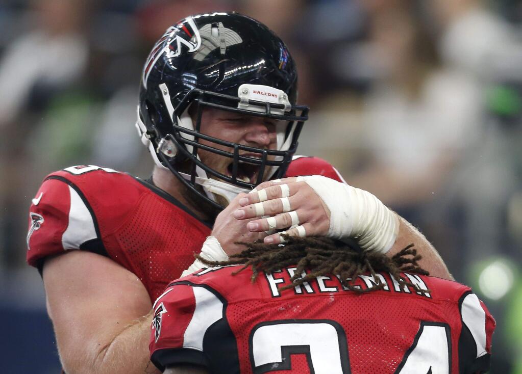 Atlanta Falcons center Mike Person, top, celebrates with running back Devonta Freeman after Freeman scored on a running play against the Dallas Cowboys, Sunday, Sept. 27, 2015, in Arlington, Texas. (AP Photo/Brandon Wade)
