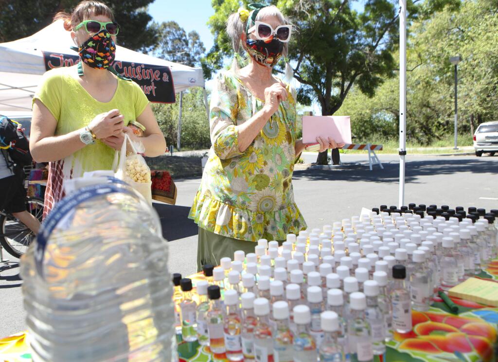 Petaluma, CA, USA. Tuesday, April 28, 2020._ Gretchen Lund (left)and her mother, Marilyn Lund picked up some hand sanitizer sold by Lightning Spirits at the Tuesday farmer's market on the east side of Petaluma. (CRISSY PASCUAL/ARGUS-COURIER STAFF)