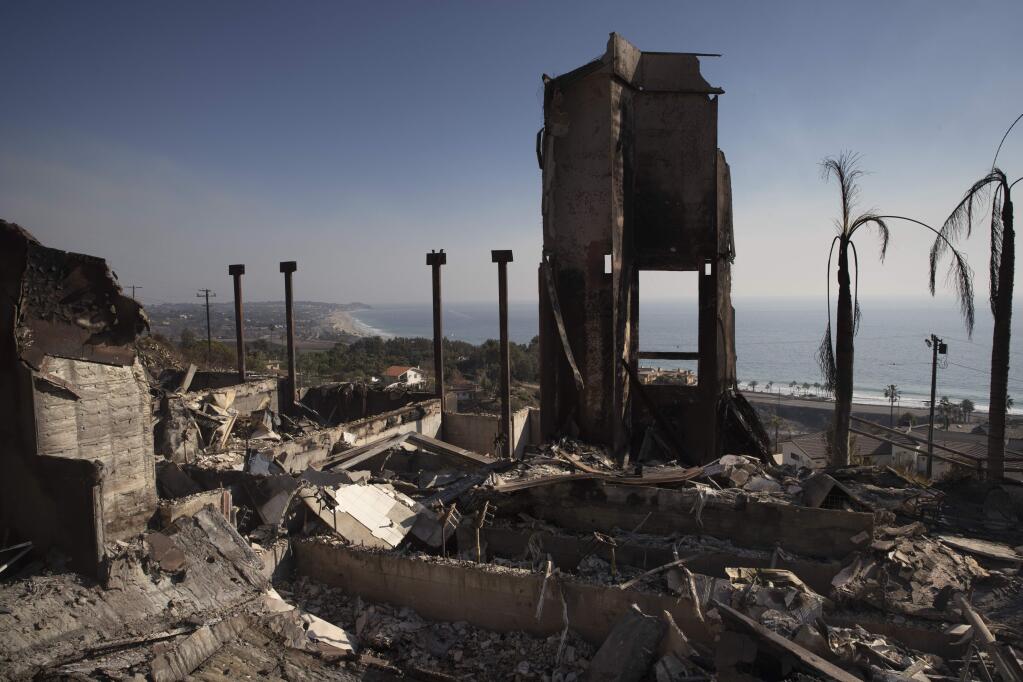 FILE - In this Nov. 11, 2018 file photo, a home burned down by a wildfire sits on a hilltop overlooking the Pacific Ocean in Malibu, Calif. Authorities estimate it will cost at least $3 billion to clear debris of 19,000 homes destroyed by California wildfires last month. State and federal disaster relief officials said Tuesday, Jan. 11, that private contractors will most likely begin removing debris in January from Butte, Ventura and Los Angeles counties and costs are likely to surpass initial estimates. (AP Photo/Jae C. Hong, File)