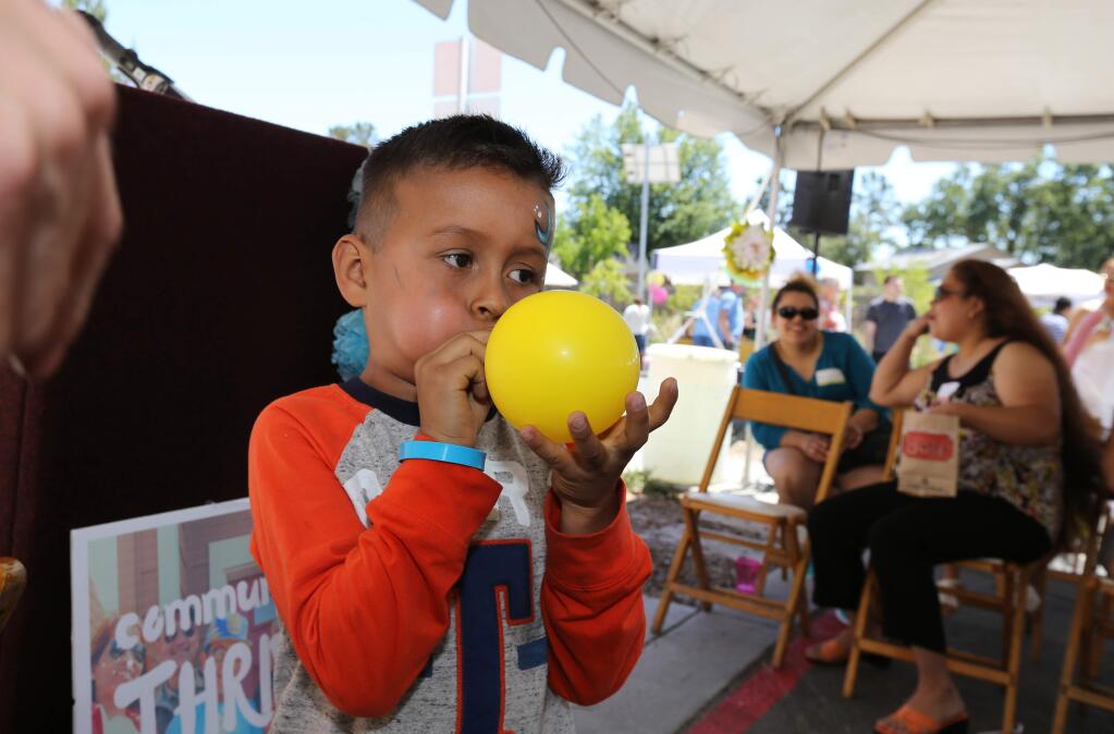 Catalina homes resident, Emmanuel Herrera, 5, blows a balloon while he volunteers in a magic show at a Catalina Street Fair for Catalina Townhomes in Santa Rosa on Saturday, June 3, 2017. (DARRYL BUSH/FOR THE PD)