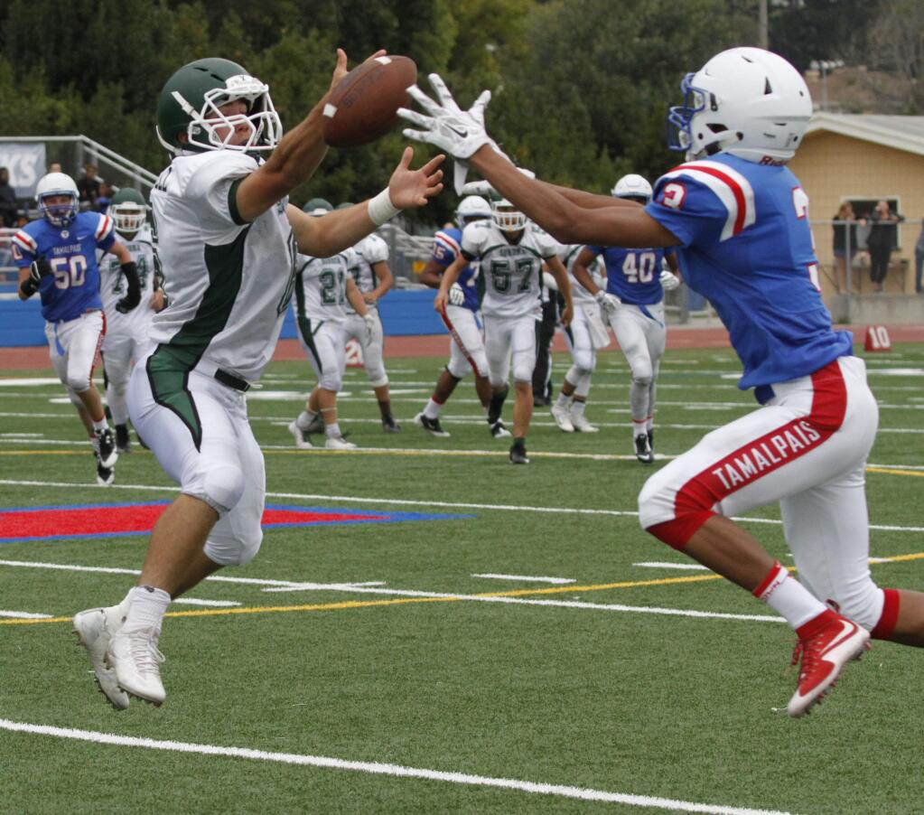 Bill Hoban/Index-TribuneSonoma's Henry Darnell, left, and a Tamalpais player both reach for a pass during Friday's opening game at Tam. Sonoma dropped their opener 13-2 to the Hawks.