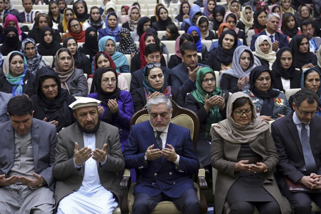 Afghanistan's Chief Executive, Abdullah Abdullah, lower center, prays during an event marking International Women's Day, in Kabul, Thursday, March 8, 2018. (AP Photo/Rahmat Gul)
