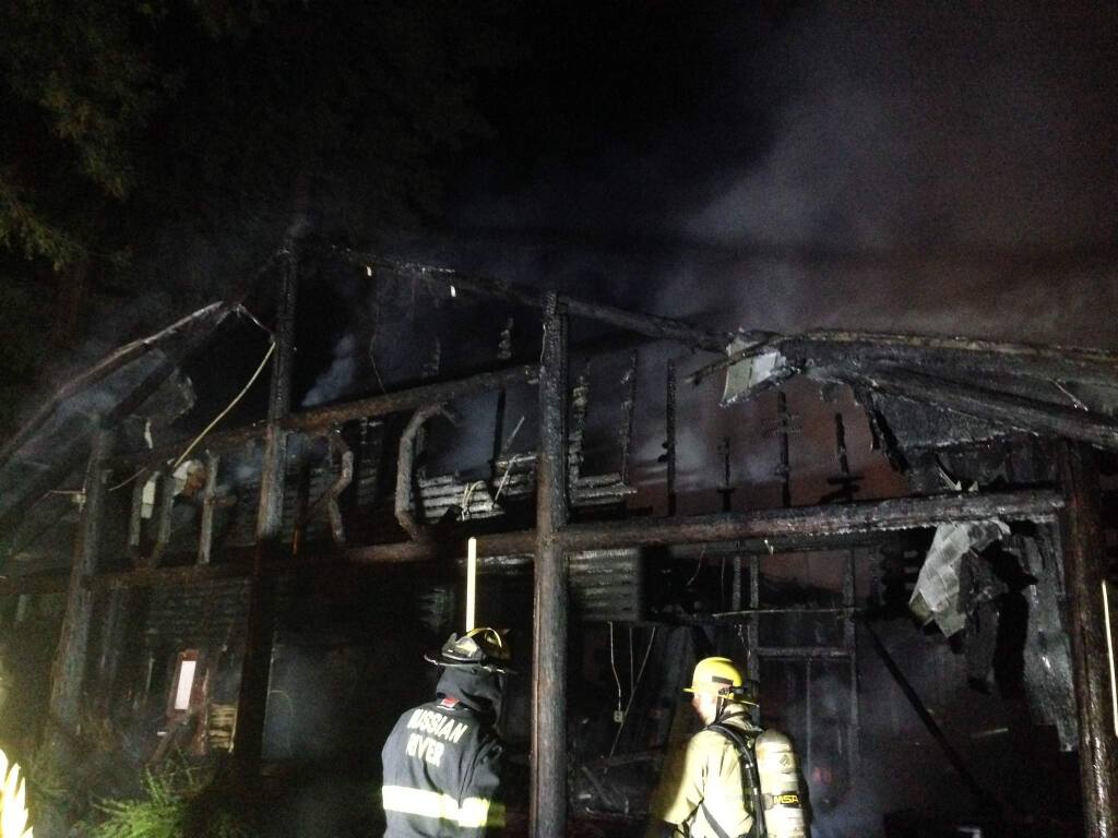 Firefighters work on the scene of a structure fire at Odd Fellows General Store, south of the Russian River outside Rio Nido on Tuesday night, Aug. 5, 2015 (Crista Jeremiason\The Press Democrat)