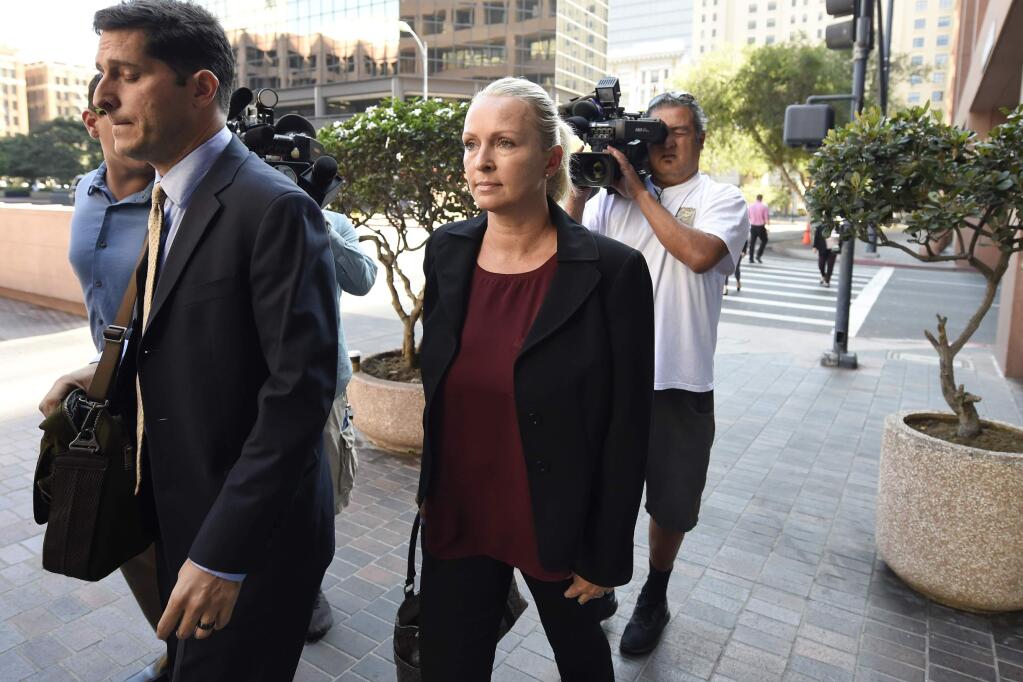 FILE - In this Thursday, Aug. 23, 2018 file photo, Margaret Hunter, center, the wife of U.S. Rep. Duncan Hunter, arrives for an arraignment hearing in San Diego. Rep. Duncan Hunter's wife is planning to change her not-guilty plea after the couple was charged with using more than $250,000 in campaign funds on vacations and other expenses. Margaret Hunter, who worked as the California Republican's campaign manager, is scheduled to appear in federal court Thursday, June 12, 2019 to change her plea.(AP Photo/Denis Poroy)
