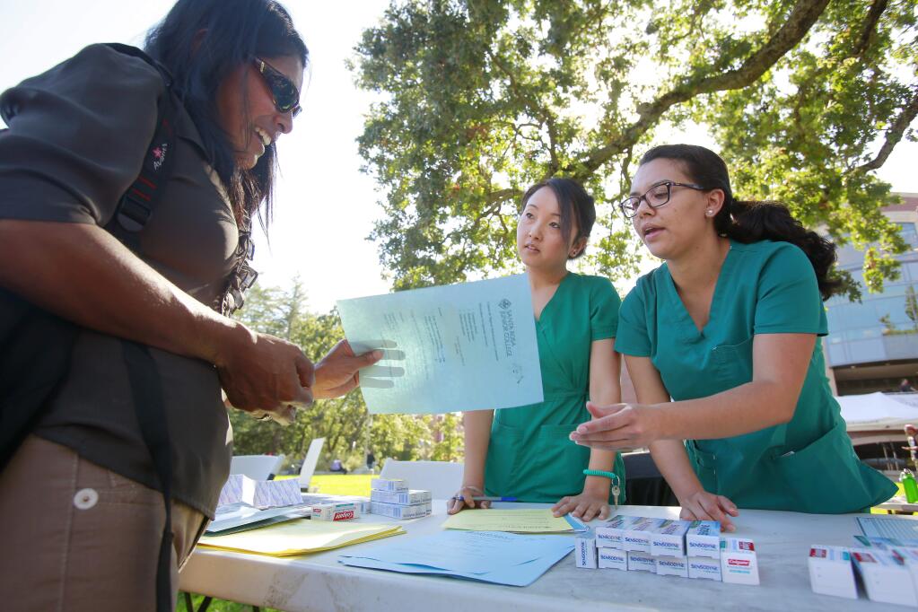 Students from the dental hygiene program at SRJC talk with prospective student Basilia Lopez, left, during student orientation at SRJC in Santa Rosa on Thursday, August 21, 2014. (Conner Jay/The Press Democrat)