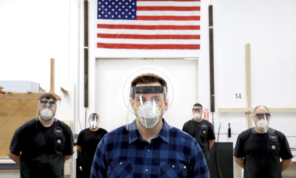 Blake Miremont and his crew at Architectural Plastics in Petaluma display face shields that they will be manufacturing, Tuesday, March 31, 2020 after refiguring Miremont's manufacturing line to help in the fight against COVID-19. (Kent Porter / The Press Democrat) 2020