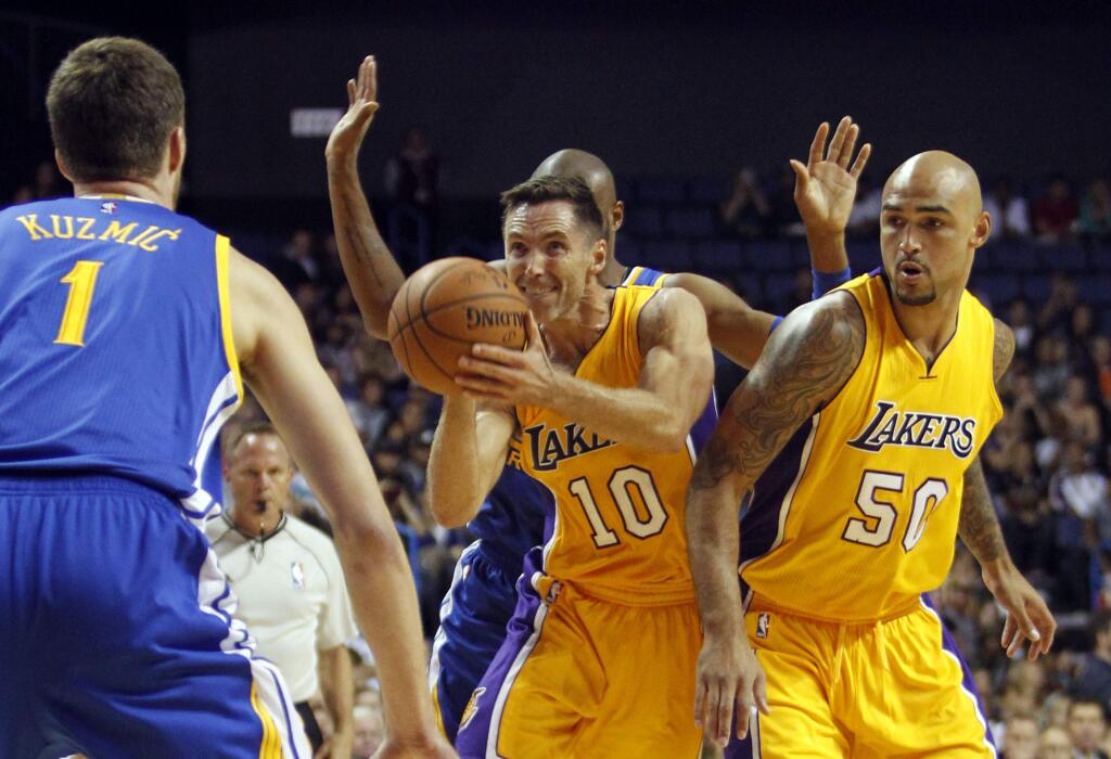 Los Angeles Lakers guard Steve Nash (10) takes a shot with center Robert Sacre (50) looking on against Golden State Warriors center Ognjen Kuzmic (1), of Bosnia, and guard Leandro Barbosa, of Brazil, from behind during the first half of a preseason NBA basketball game, Sunday, Oct. 12, 2014, in Ontario, Calif. (AP Photo/Alex Gallardo)