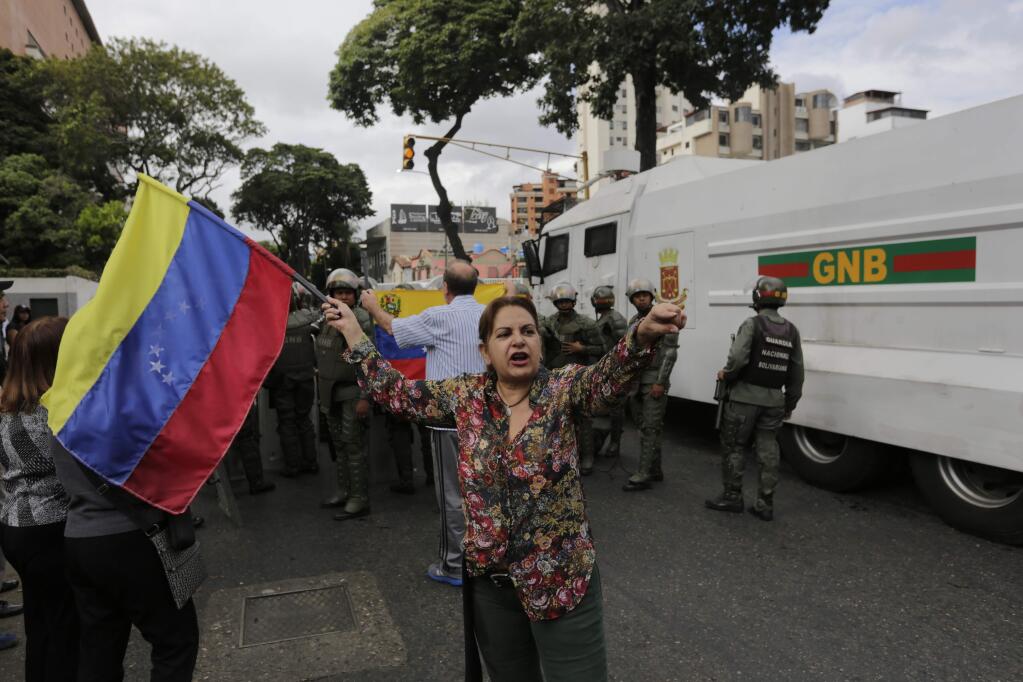 Venezuelan Bolivarian National Guardsmen block opposition members during a protest march against President Nicolas Maduro in Caracas, Venezuela, Wednesday, Jan. 23, 2019. Venezuela's re-invigorated opposition faces a crucial test Wednesday as it seeks to fill streets nationwide with protesters in an appeal to the military and the poor to shift loyalties that until recently looked solidly behind Maduro's government. (AP Photo/Fernando Llano)
