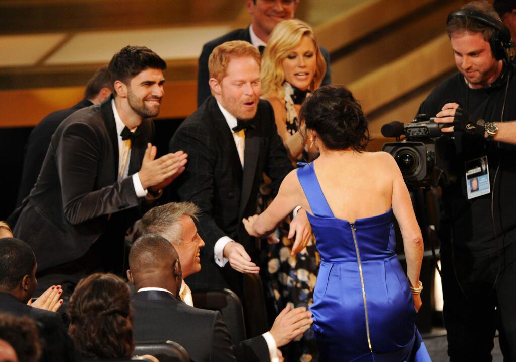Gail Mancuso accepts the award for outstanding directing for a comedy series for her work on Modern Family at the 66th Annual Primetime Emmy Awards at the Nokia Theatre L.A. Live on Monday, Aug. 25, 2014, in Los Angeles. Looking on from left are Justin Mikita, Jesse Tyler Ferguson and Julie Bowen. (Photo by Chris Pizzello/Invision/AP)