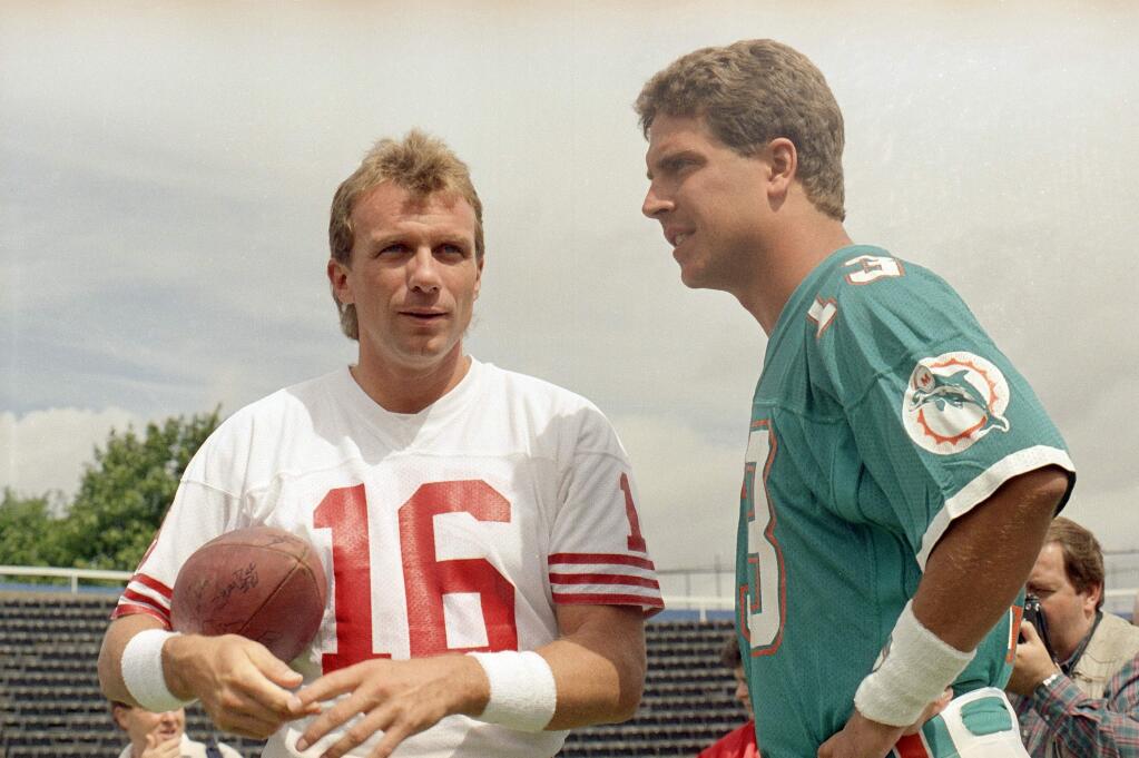 San Francisco 49ers' quarterback Joe Montana, left and Miami Dolphins quarterback Dan Marino chat during a training session at Crystal Palace, July 26, 1988, in London. (AP Photo/Doug Jennings)