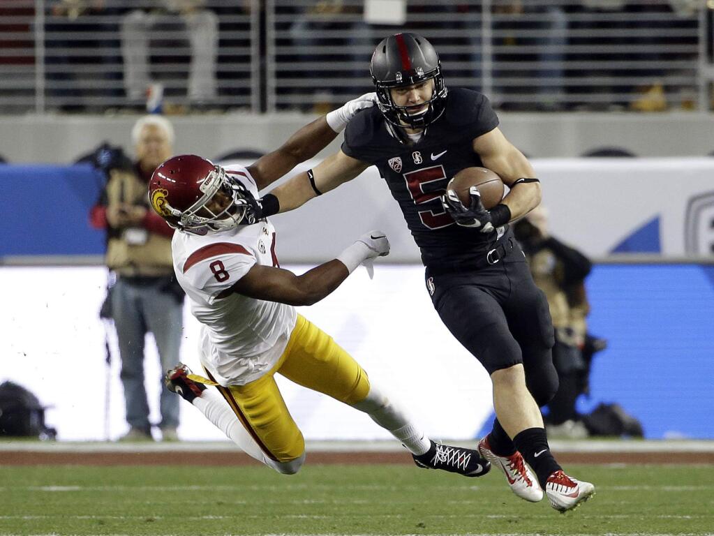 In this Dec. 6, 2015, file photo, Stanford running back Christian McCaffrey (5) stiff-arms USC's Iman Marshall on a kickoff return during the Pac-12 championship game in Santa Clara. (AP Photo/Marcio Jose Sanchez, File)