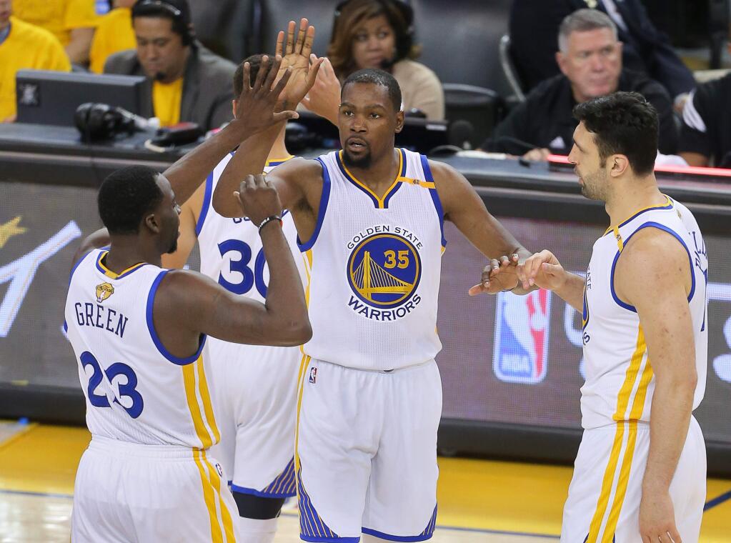 Golden State Warriors forward Kevin Durant high-fives teammates Draymond Green and Zaza Pachulia during Game 2 of the NBA Finals in Oakland on Sunday, June 4, 2017. The Warriors defeated the Cavaliers 132-113. (Christopher Chung / The Press Democrat)