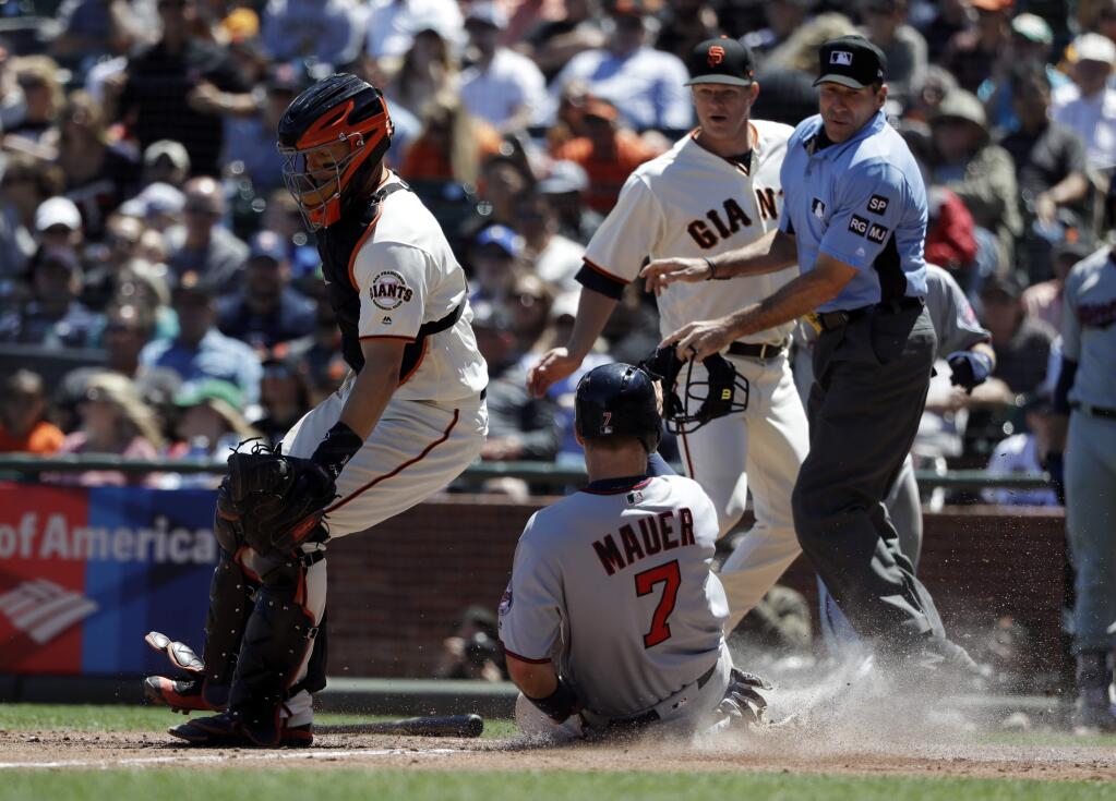 Minnesota Twins' Joe Mauer (7) scores past San Francisco Giants catcher Nick Hundley, left, after a single from Robbie Grossman during the fifth inning of a baseball game Sunday, June 11, 2017, in San Francisco. (AP Photo/Marcio Jose Sanchez)