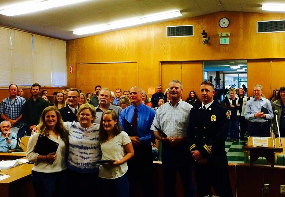 FacebookCOMMUNITY RECOGNITION: Tena Jackson and her daughters, Koko, foreground left, and Emmy, are surrounded by a crew of first responders at a Petaluma City Council meeting where the girls were honored for keeping their mother alive by using CPR until the emergency responders arrived to take over.