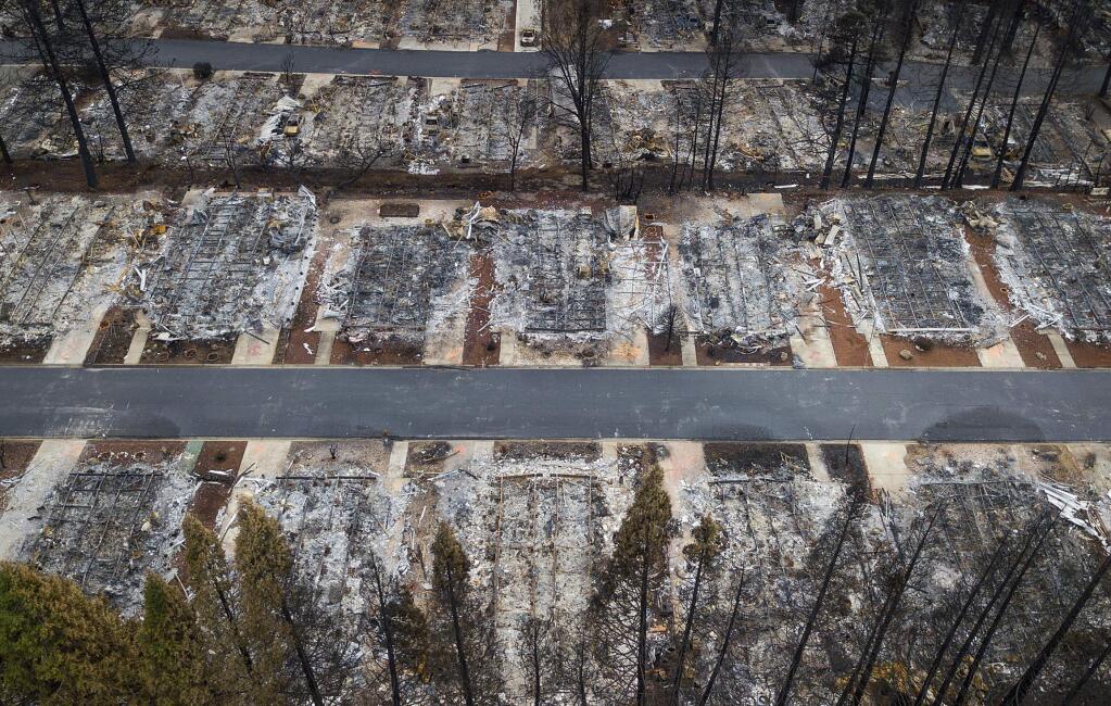 FILE- This Dec. 3, 2018, file photo, shows homes leveled by the Camp Fire line the Ridgewood Mobile Home Park retirement community in Paradise, Calif. Pacific Gas & Electric limped into bankruptcy vilified for its long-running neglect of a crumbling electrical grid that ignited horrific Northern California wildfires that left entire cities in ruins. After nearly a year-and-a-half of wrangling during one of the most complex bankruptcy cases in U.S. history, it's unclear if PG&E is now any better equipped to protect the 16 million people who rely on it for power. (AP Photo/Noah Berger, File)