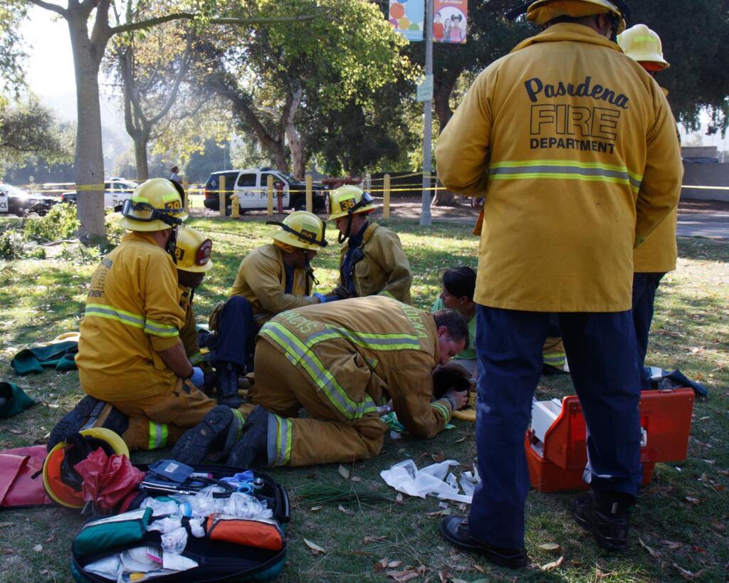 In this image released by Pasadena Fire, Pasadena firefighters treat an injured child after a tree that fell near Kidspace Children's Museum in Pasadena, Calif., Tuesday, July 28, 2015. Witnesses say the tree made a cracking sound and came down on children just as a summer day camp at the museum was letting out for the day. (Jamie Nicholson/Pasadena Fire via AP)