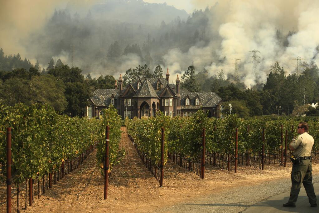 AFTER: A wildfire burns behind Ledson Winery Saturday, Oct. 14, 2017, in Santa Rosa, Calif. The winery remained unscathed. (AP Photo/Jae C. Hong)