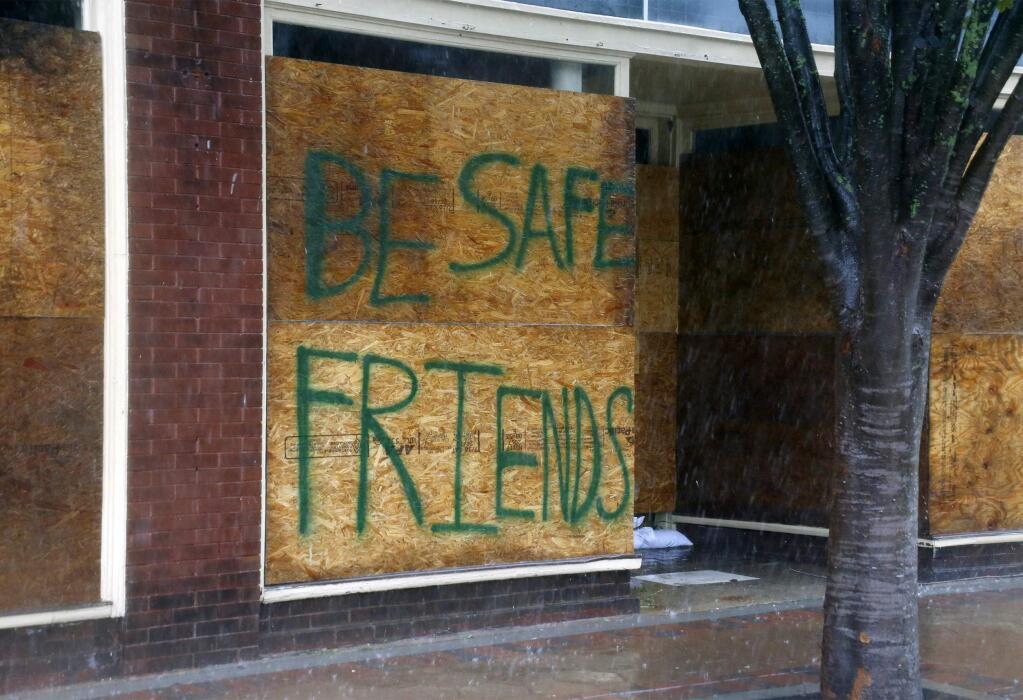 A message on a boarded-up business encourages people to be safe as Hurricane Florence hit New Bern, North Carolina on Friday. (CHRIS SEWARD / Associated Press)