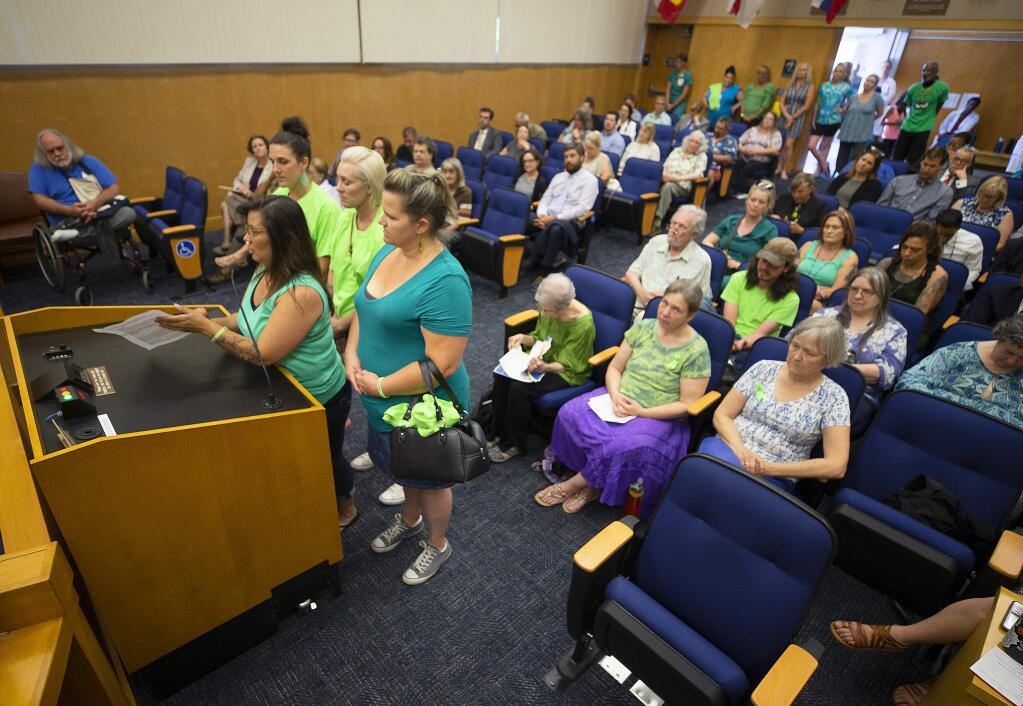 Tanya Sarcos, left at podium, an employee with the Santa Rosa Treatment Program, brought her Rollin Rosie's Car Club friends to support her and funding for mental health and addiction education during public discussion of the budget at the Sonoma County Board of Supervisors on Tuesday. (photo by John Burgess/The Press Democrat)