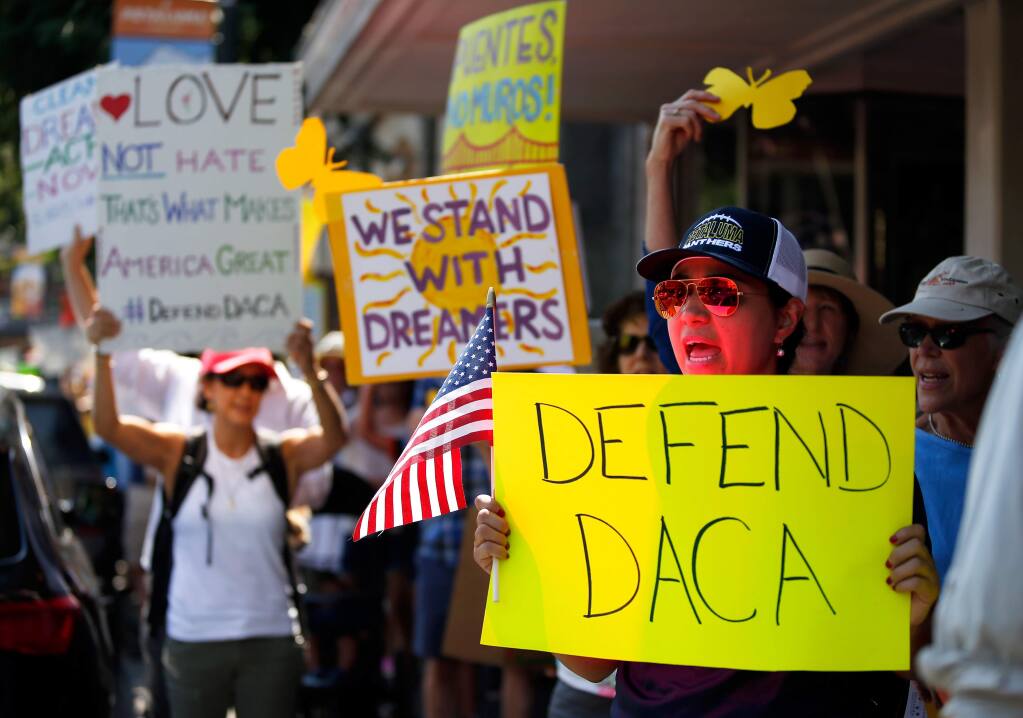 Zaide Arenas, right, and other demonstrators chant and march along Petaluma Boulevard to protest the repeal of the Delayed Action for Childhood Arrivals (DACA) program and to show their support for dreamers and all immigrants, in Petaluma, California on Sunday, September 10, 2017. Some demonstrators carry paper monarch butterflies to represent migration without borders. (Alvin Jornada / The Press Democrat)