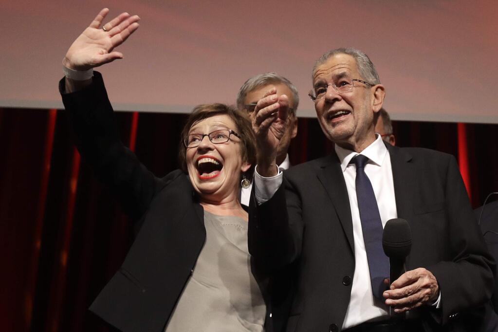 Presidential candidate Alexander Van der Bellen, right a former leading member of the Greens Party, and Van der Bellen's wife Doris Schmidauer celebrate on the podium at a party of their supporters in Austria's capital Vienna Sunday, Dec. 4, 2016, after the first official results from the Austrian presidential election showed left-leaning candidate Alexander Van der Bellen with what appears to be an unbeatable lead over right-winger Norbert Hofer. (AP Photo/Matthias Schrader)