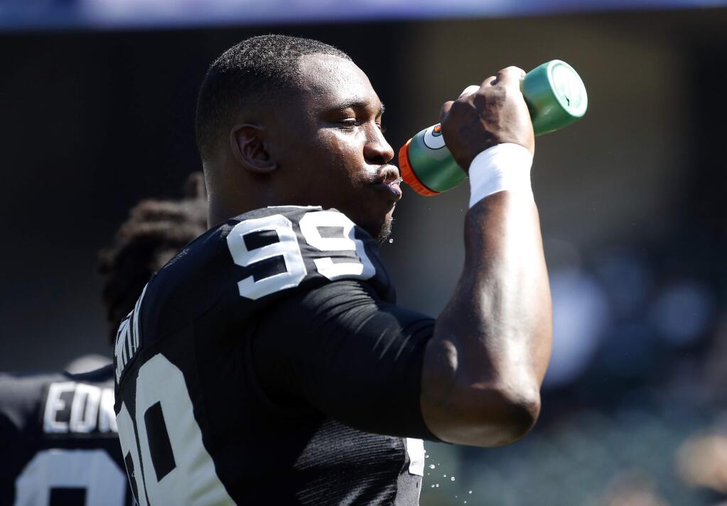 Oakland Raiders defensive end Aldon Smith drinks Gatorade during a game against the Baltimore Ravens Sunday, Sept. 20, 2015, in Oakland. (AP Photo/Tony Avelar)