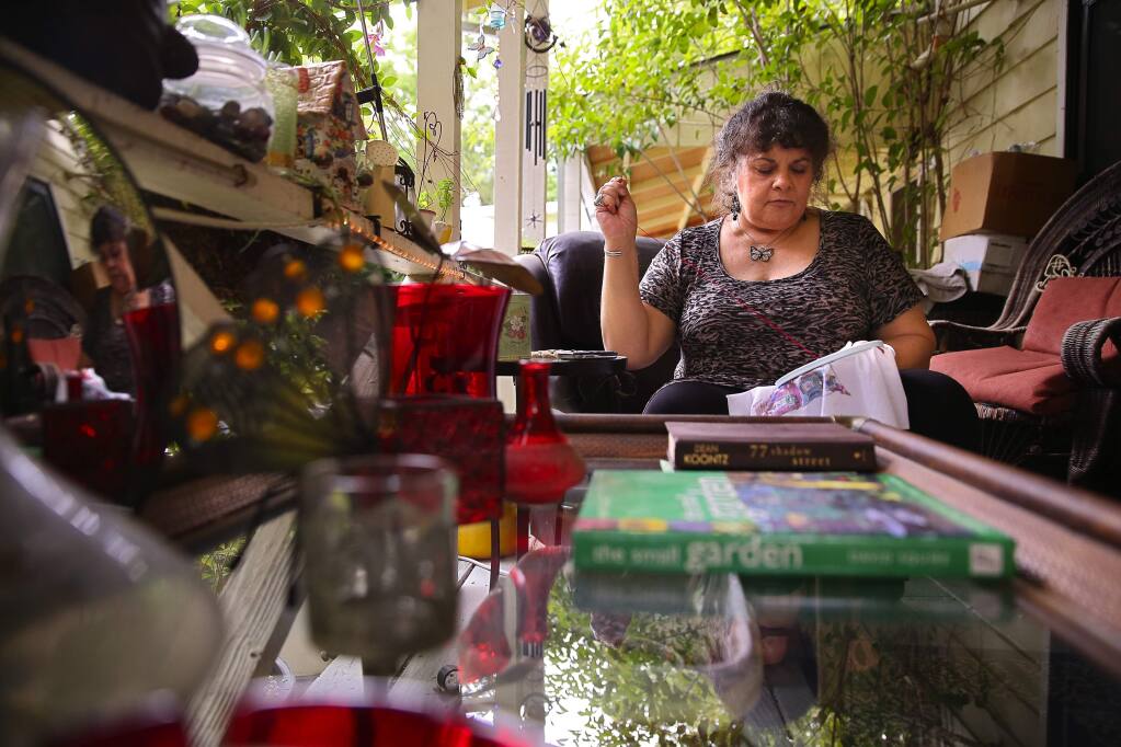 PHOTO: 2 BY CHRISTOPHER CHUNG/ THE PRESS DEMOCRAT -Laura Blackmore does needlepoint on the porch outside her room at Stony Point Commons in Santa Rosa. Blackmore, who was homeless for two years, has lived at the facility for six years.