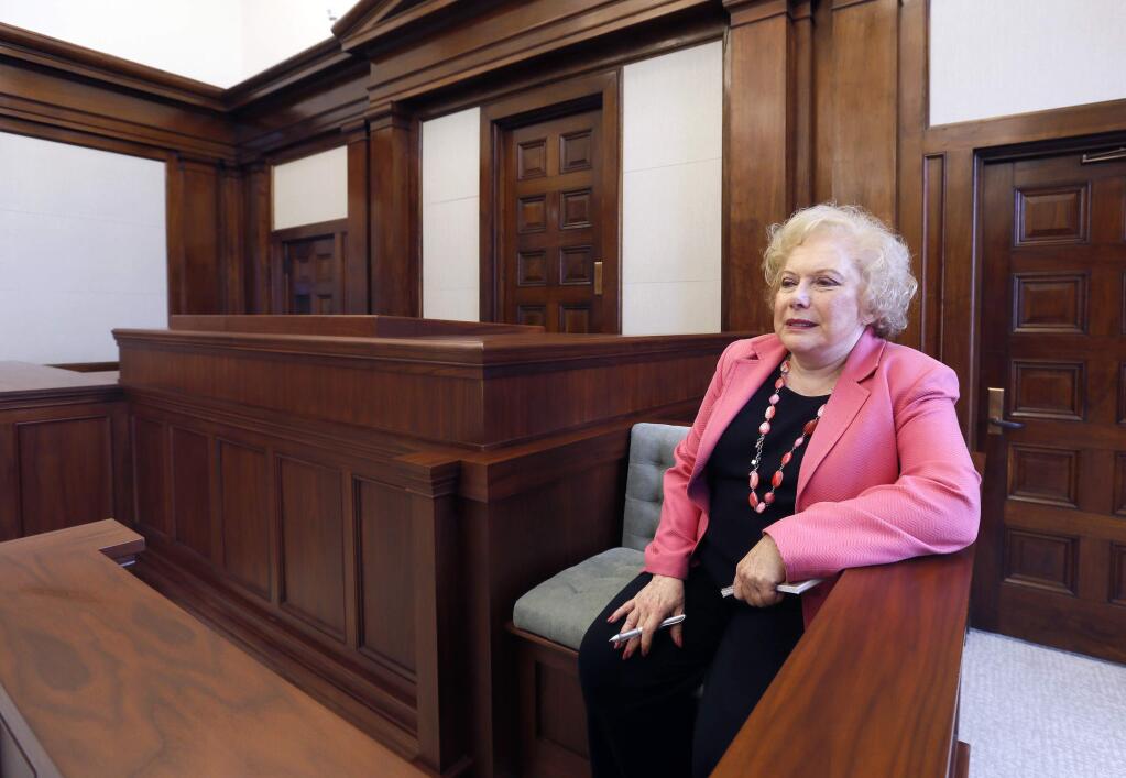 In this Oct. 20, 2014 photo, Associated Press special correspondent Linda Deutsch sits in a replica of the courtroom where the Charles Manson trial was held, at the newly renovated Hall of Justice in Los Angeles. Deutsch said, ' I was trying out the one seat I never had in a courtroom.' Deutsch, who wraps up a 48-year career with the AP on Monday, Dec. 22, 2014, was a young general assignment reporter when she was inadvertently shoved into the court beat, something that would make her arguably the news organizations most recognizable reporter. (AP Photo/Nick Ut)