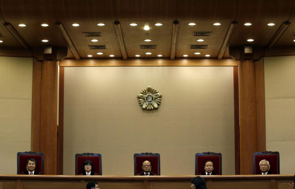 Park Han-chul, center, president of South Korea's Constitutional Court, sits with other judges before the judgment at the Constitutional Court in Seoul, South Korea, Thursday, Feb. 26, 2015. The court on Thursday abolished a 62-year-old law that bans extramarital affairs, ruling that the law suppresses personal freedoms. The ruling by the Constitutional Court could potentially affect thousands of individuals who faced adultery charges since Oct. 31, 2008, a day after the court previously upheld the adultery ban. Current charges could be thrown out and anyone given a guilty verdict would be eligible for a retrial, according to a court official, who didn't want to be named, citing office rules. (AP Photo/Lee Jin-man)