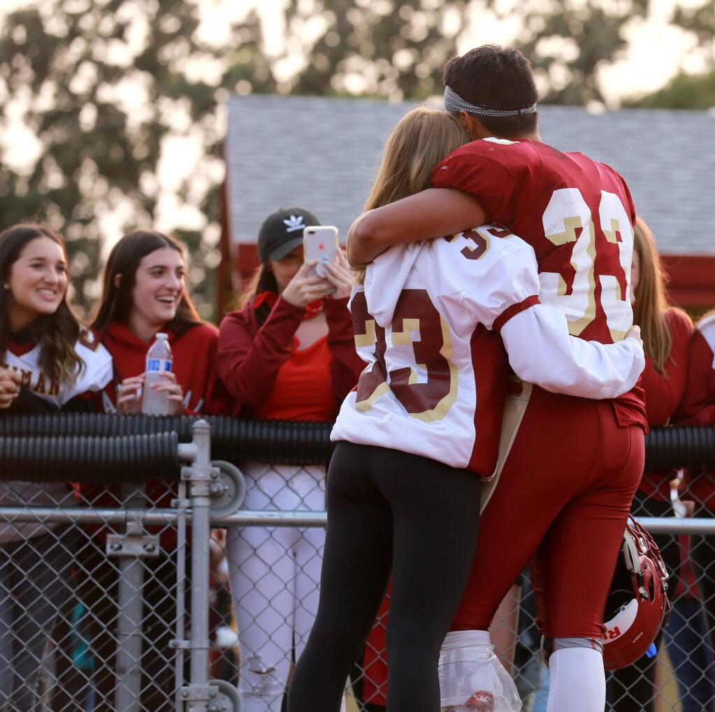 Cardinal Newman's Emylio Vega (33) gets hug from Makayla Nelsen, both Juniors, after a JV game against Sutter at Cardinal Newman High School in Santa Rosa, on Friday, August 24, 2018. (Photo by Darryl Bush / For The Press Democrat)