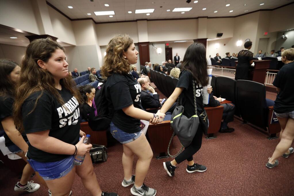 Student survivors from Marjory Stoneman Douglas High School, where over a dozen students and faculty were killed in a mass shooting on Wednesday, enter a house legislative committee hearing, to interrupt and challenge lawmakers on gun control reform, in Tallahassee, Fla., Wednesday, Feb. 21, 2018. (AP Photo/Gerald Herbert)