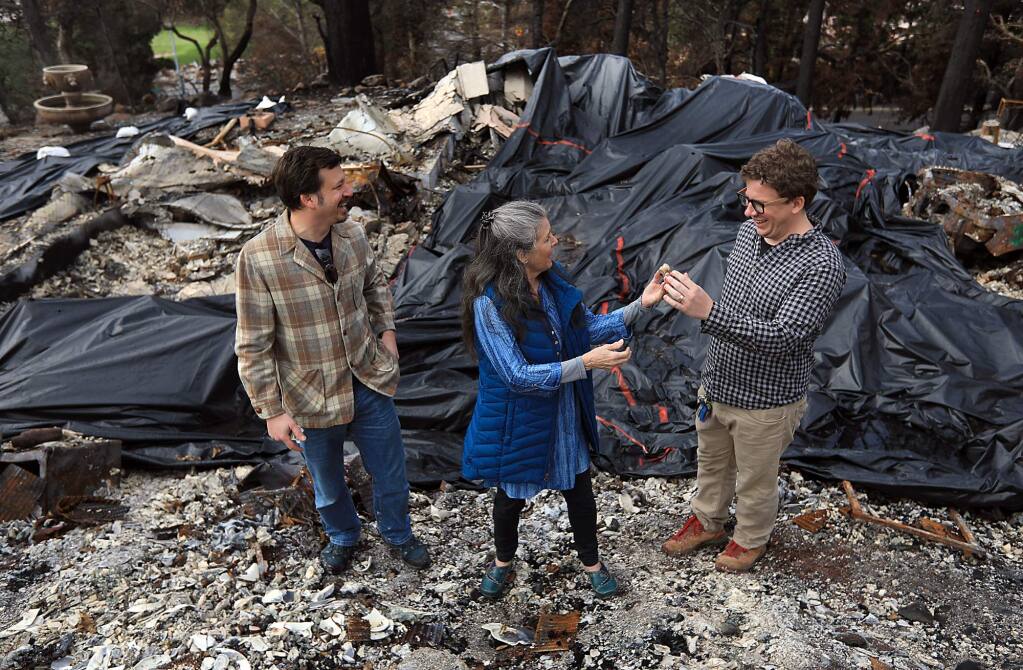 Evan Neumann, left, 45, and Mark Neumann, 32, share a laugh with their mother Debbie Neumann after finding a baby Jesus figurine at her Fountaingrove home, Wednesday Jan. 10, 2018. The two brothers were arrested on their way to sift debris at the home for being in the fire zone curfew and charged with misdemeanors. They were attempting to retrieve family belongings before the first rain set in. (Kent Porter / Press Democrat) 2018