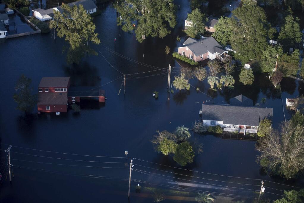 Floodwaters inundate homes after Florence struck the Carolinas, Monday, Sept. 17, 2018, in Conway, S.C. (AP Photo/Sean Rayford)
