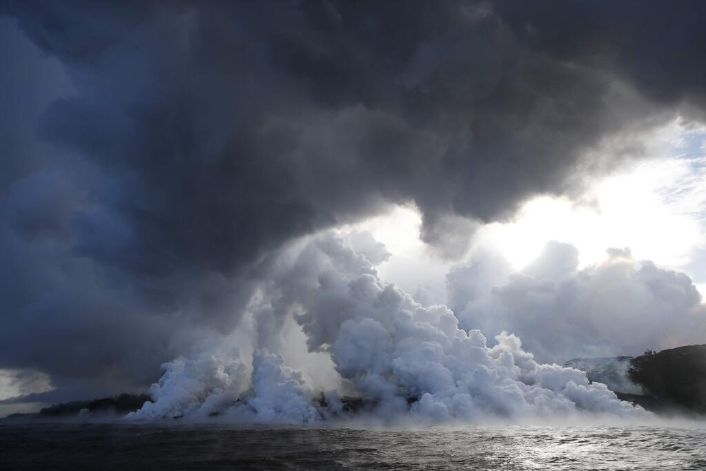FILE - In this May 20, 2018 file photo, plumes of steam rise as lava enters the ocean near Pahoa, Hawaii. An explosion sent lava flying through the roof of a tour boat off Hawaii's Big Island, injuring at least 13 people Monday, July 16, 2018, officials said. The people were aboard a tour boat that takes visitors to see lava from an erupting volcano plunge into the ocean. (AP Photo/Jae C. Hong, File)