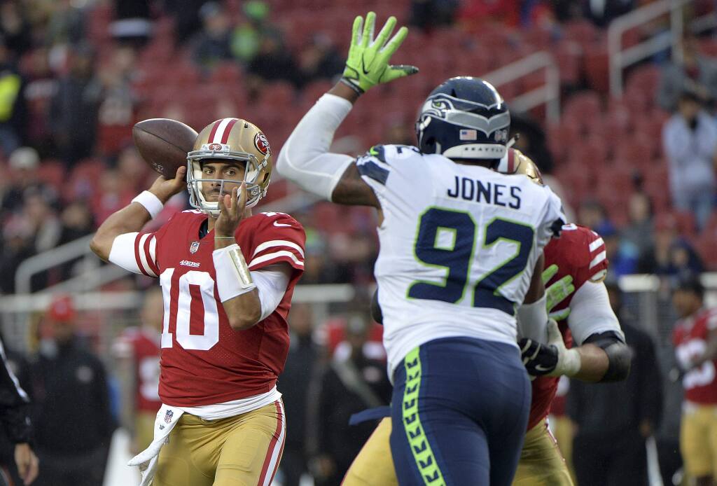 San Francisco 49ers quarterback Jimmy Garoppolo, left, throws against the Seattle Seahawks during the second half Sunday, Nov. 26, 2017, in Santa Clara. (AP Photo/Don Feria)