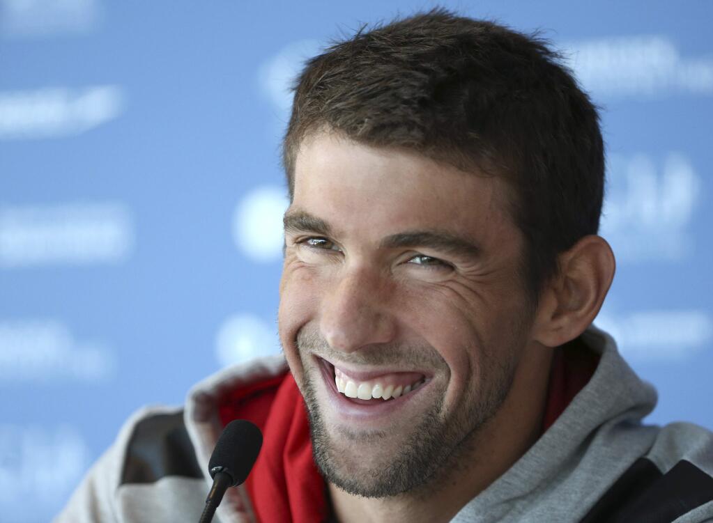 In this Aug. 20, 2014, file photo, U.S. swimmer Michael Phelps laughs during a press conference ahead of the Pan Pacific swimming championships in Gold Coast, Australia. (AP Photo/Rick Rycroft, File)