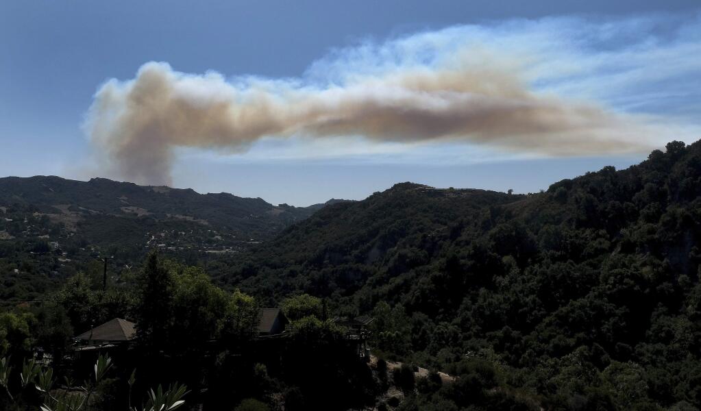 A giant plume of smoke rises from a fire in Pacific Palisades, as seen from Topanga Canyon in Topanga, Calif., Monday, Oct. 21, 2019. (Dean Musgrove/The Orange County Register via AP)