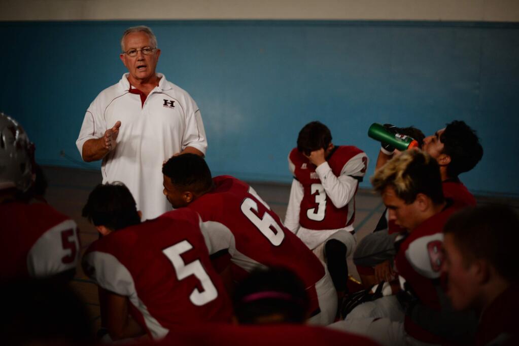 Head coach Dave Stine talking to his players before the start of a Healdsburg High School home game against the Harker Eagles, Sept. 15, 2017. (Erik Castro/for The Press Democrat)