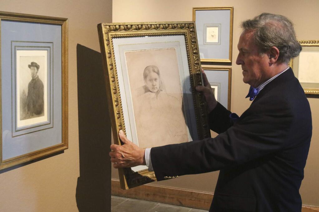 Robert Flynn Johnson, Curator Emeritus with the de Young Legion of Hounor museum, holds a famous piece of artwork by Edgar Degas a black crayon on plain colored paper drawing of Mille Dembowska, 1958-1959, as he stands in front of a self portrait by the artist from 1857, at the Petaluma Art Center on Monday, June 15, 2015. The art center is hosting an exhibit for impressionist Edgar Degas. (SCOTT MANCHESTER/ARGUS-COURIER STAFF)