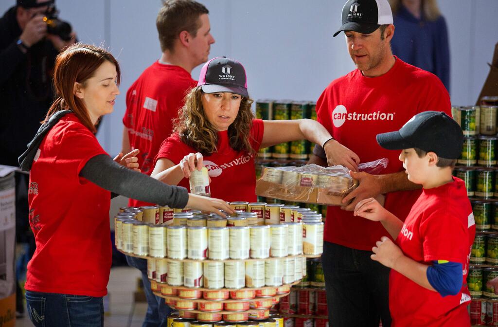 From left, Lisa Sparks, Lisa Freedman, Steven Wright and Kelsey Jennings, 11 build the head of a CANstruction of Charlie Brown at the Coddintown Mall on Saturday to benefit the Redwood Empire Food Bank. (photo by John Burgess/The Press Democrat)