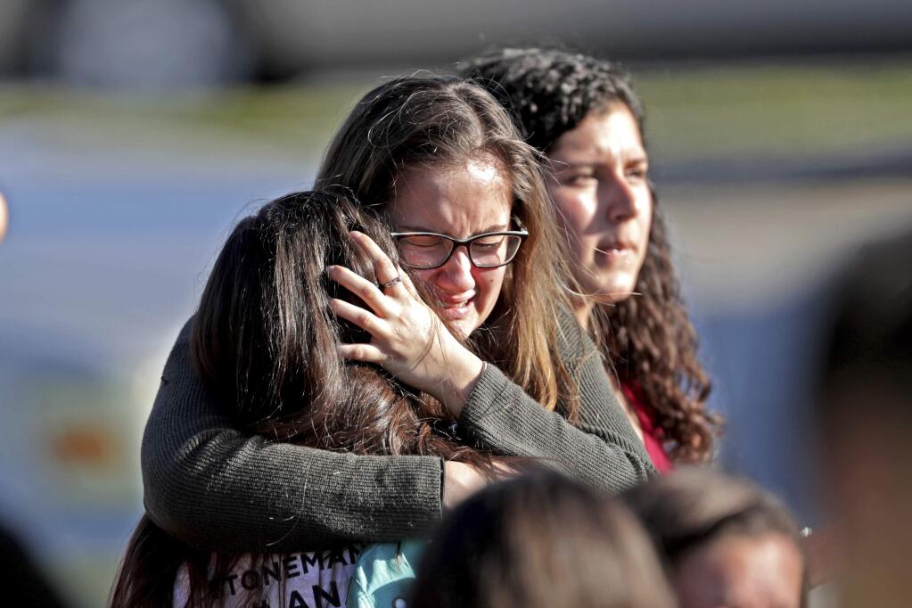 Students released from a lockdown embrace following following a shooting at Marjory Stoneman Douglas High School in Parkland, Florida on Wednesday. (JOHN McCALL / South Florida Sun-Sentinel)