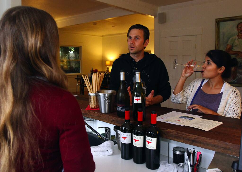 Hawkes tasting room employee Janne Campbell talks to David Chaffee and Connie Camacho, both of San Diego, about the wines at the Hawkes Sonoma Square tasting room. October 3, 2011.
