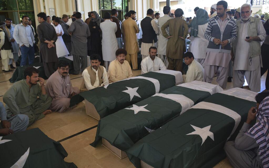People wait to receive the bodies of their family members who died in an attack on the Police Training Academy, in Quetta, Pakistan, Tuesday, Oct. 25, 2016. Militants wearing suicide vests stormed a Pakistani police academy in the southwestern city of Quetta overnight, killing dozens of people, mostly police cadets and recruits, and waging a ferocious gun battle with troops that lasted into early hours Tuesday. (AP Photo/Arshad Butt)