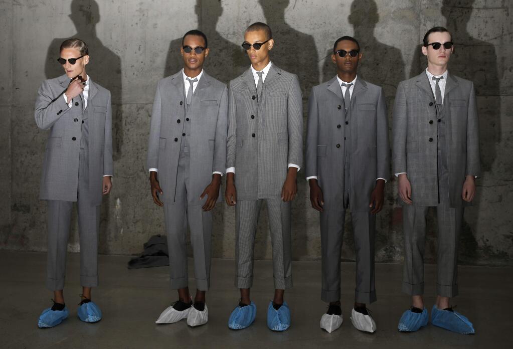 Models line-up to enter a mirrored room for a presentation by Thom Browne during Men's Fashion Week in New York, Tuesday, July 14, 2015. New York is hosting its first standalone Mens Fashion Week in 15 years this week. (AP Photo/Seth Wenig)