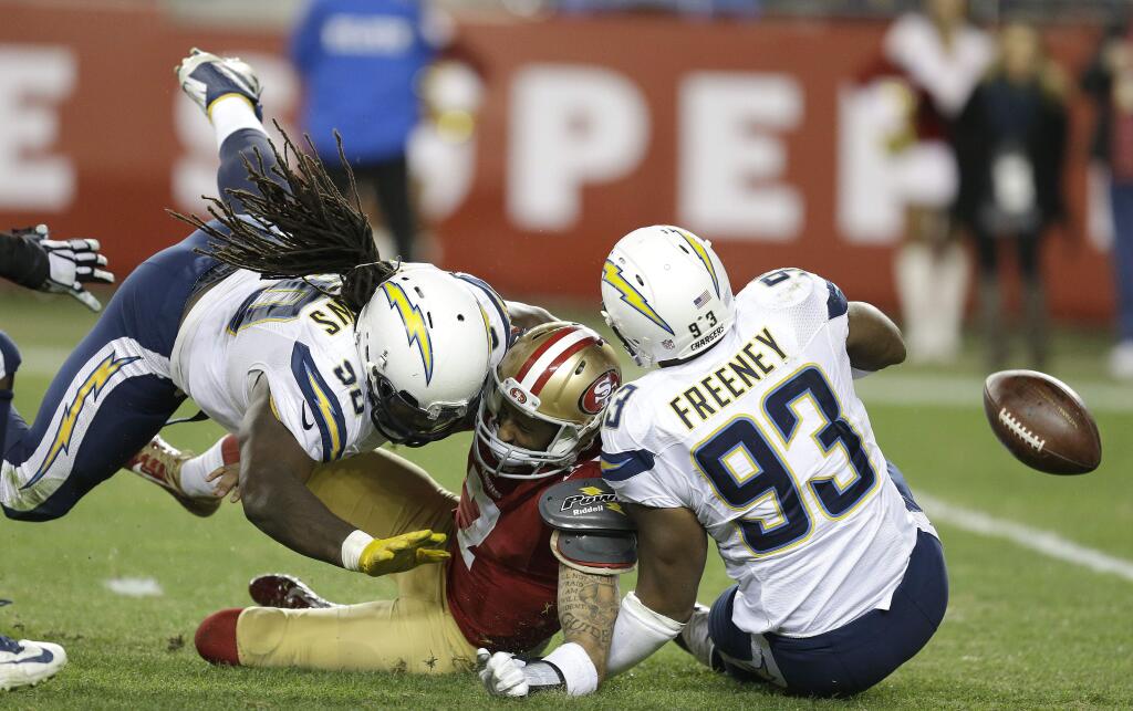 San Francisco 49ers quarterback Colin Kaepernick, center, fumbles the ball after being sacked by San Diego Chargers outside linebacker Dwight Freeney (93) and defensive tackle Ricardo Mathews (90) during the third quarter of an NFL football game in Santa Clara, Calif., Saturday, Dec. 20, 2014. San Diego Chargers defensive end Corey Liuget recovered the ball for a touchdown. (AP Photo/Ben Margot)