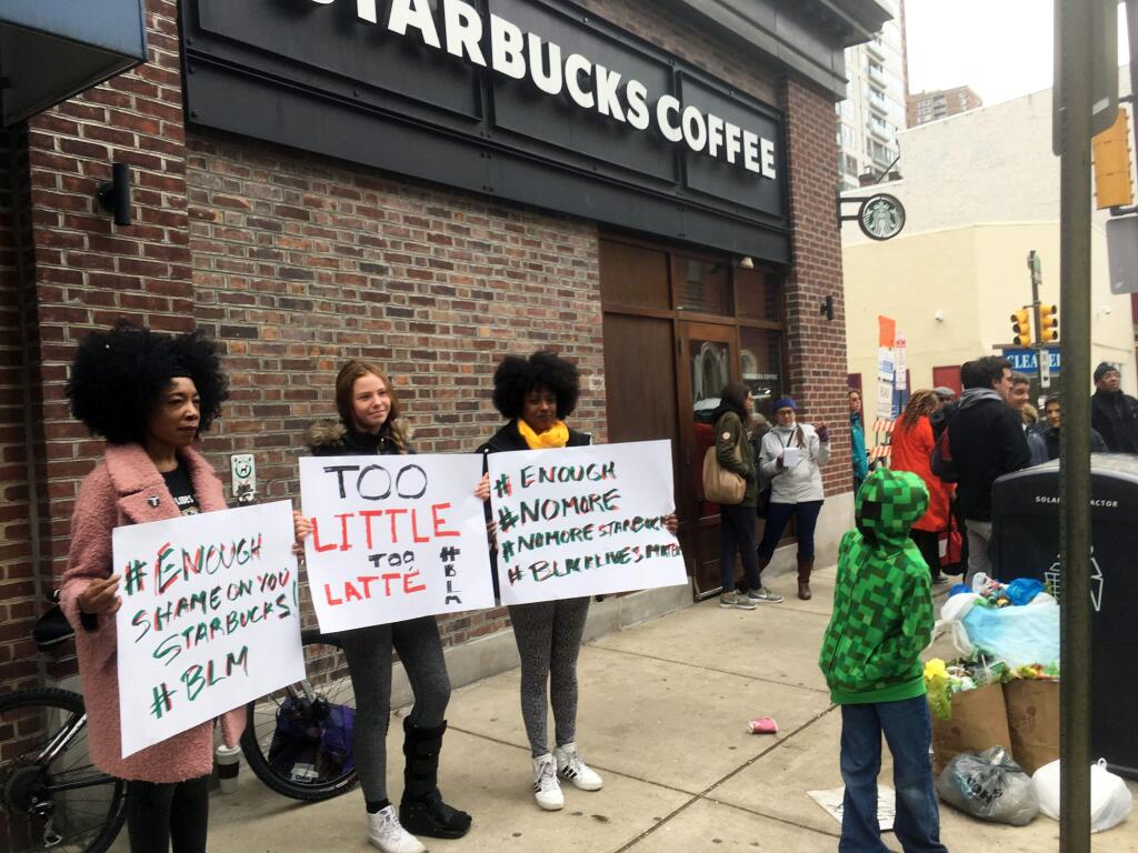 Protesters gather outside a Starbucks in Philadelphia, Sunday, April 15, 2018, where two black men were arrested Thursday after Starbucks employees called police to say the men were trespassing. The arrest prompted accusations of racism on social media. Starbucks CEO Kevin Johnson posted a lengthy statement Saturday night, calling the situation 'disheartening' and that it led to a 'reprehensible' outcome. (AP Photo/Ron Todt)