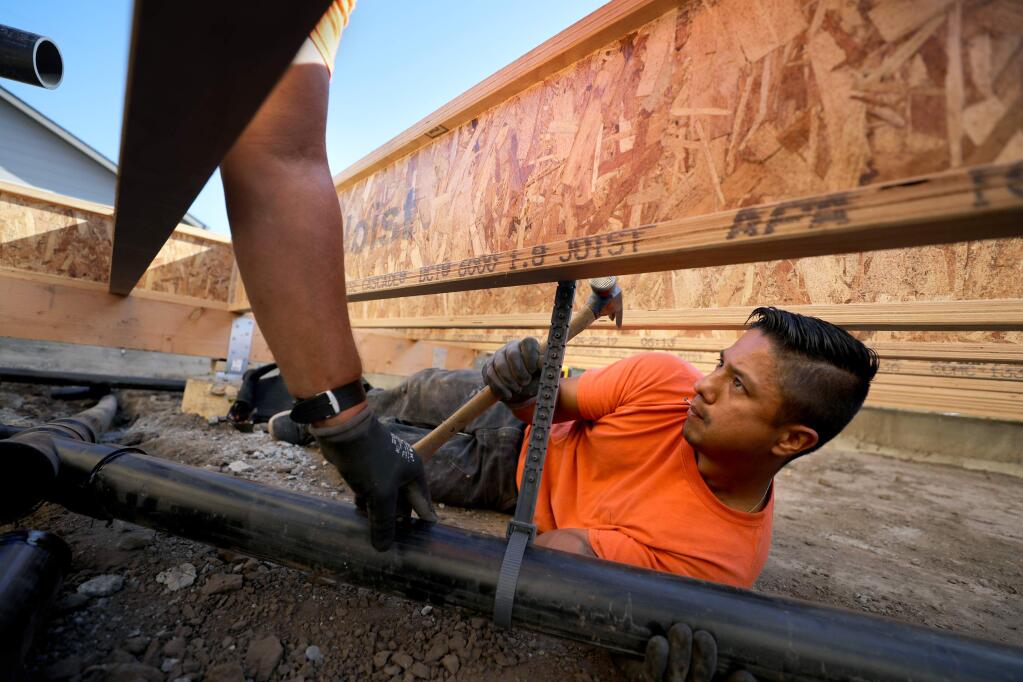 Oscar Pena, an employee of Hogan Plumbing and Radiant Systems, lays the pipes for the plumbing to a septic system with access to a possible future sewer system at 68 Chelsea Drive in Larkfield-Wikiup on Tuesday, Sept. 10, 2019. (BETH SCHLANKER/ The Press Democrat)